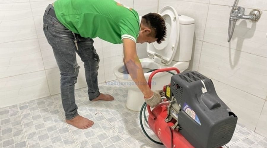 Nhân viên đang thông bồn cầu tại quận Cầu Giấy